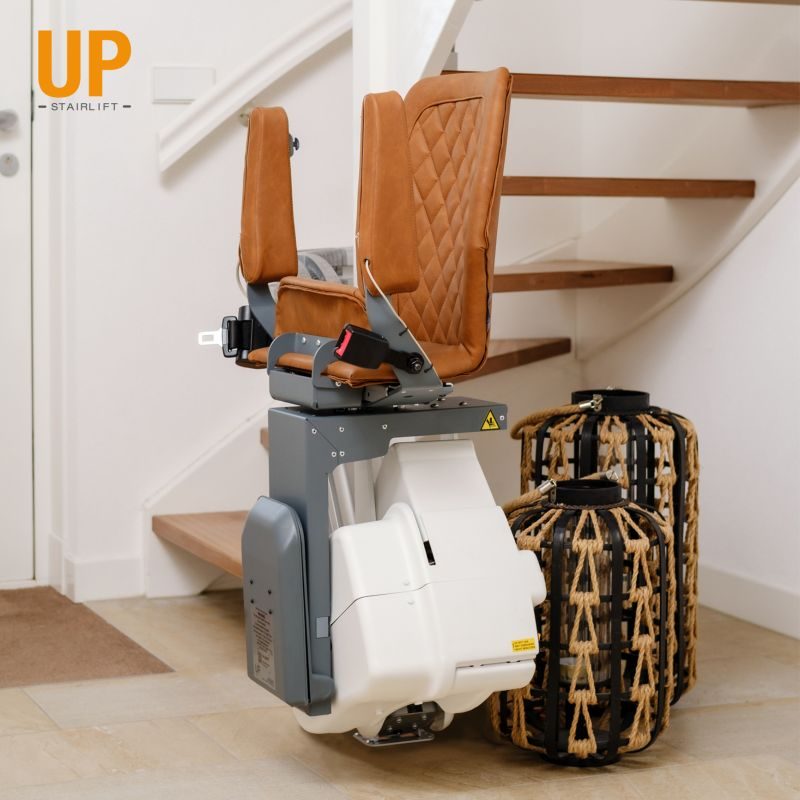 Treppenlift mit braunen Sitzen, montiert an einer Treppe, daneben zwei Koffer in Ibbenbüren 