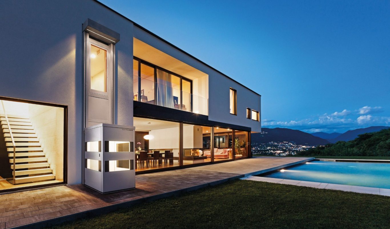 Modernes Haus mit großen Fenstern, Pool und stilvoller Terrasse bei Dämmerung in Münster