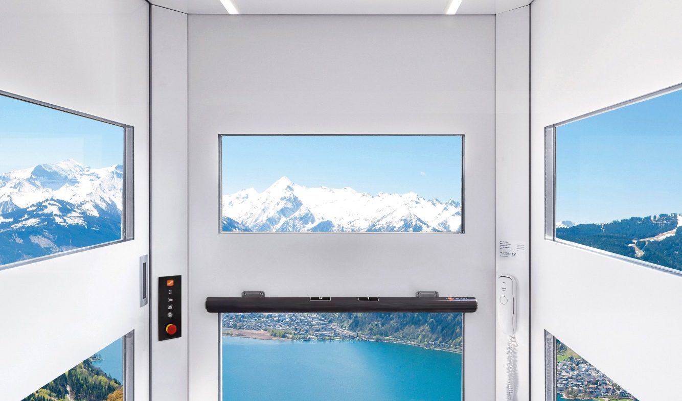 Blick aus einem Glasaufzug auf Berge und einen See, klare Sicht und Tageslicht in Münster